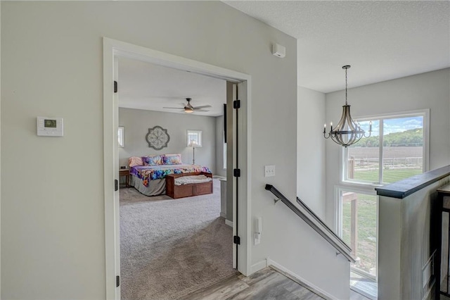 17690 Clayton Ave, Rosemount, MN 55068 - staircase with a chandelier, a ceiling fan, baseboards, wood finished floors, and a textured ceiling