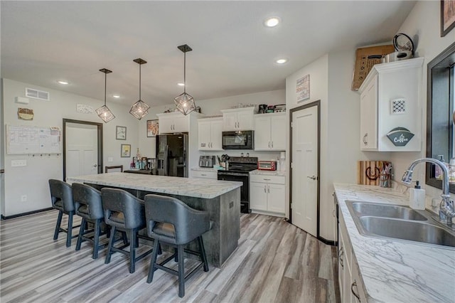 17690 Clayton Ave, Rosemount, MN 55068 - kitchen featuring black appliances, a sink, light wood finished floors, a kitchen bar, and recessed lighting