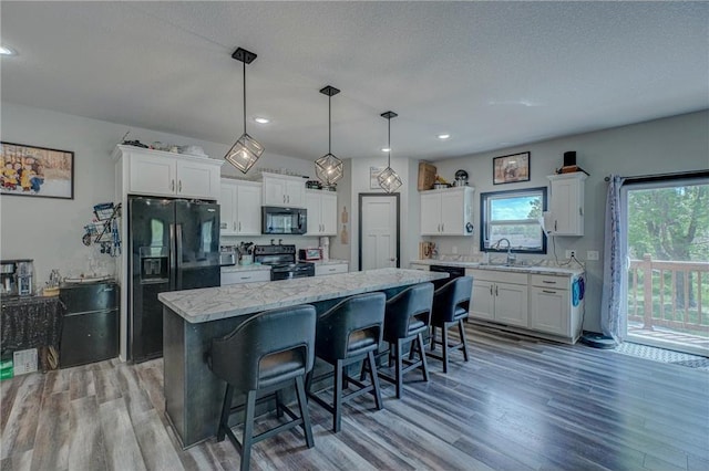 17690 Clayton Ave, Rosemount, MN 55068 - kitchen with black appliances, a center island, white cabinetry, light wood-style flooring, and recessed lighting