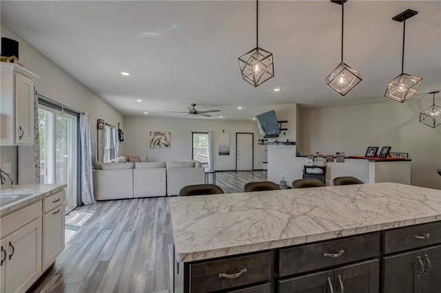 17690 Clayton Ave, Rosemount, MN 55068 - kitchen with white cabinetry, open floor plan, light countertops, a ceiling fan, and light wood-style floors