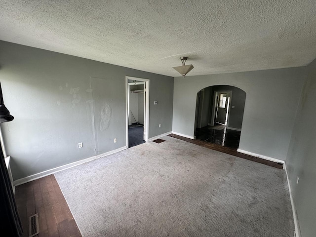 30728 113th St, Wilmot, WI 53181 - carpeted spare room featuring arched walkways, baseboards, a textured ceiling, and wood finished floors