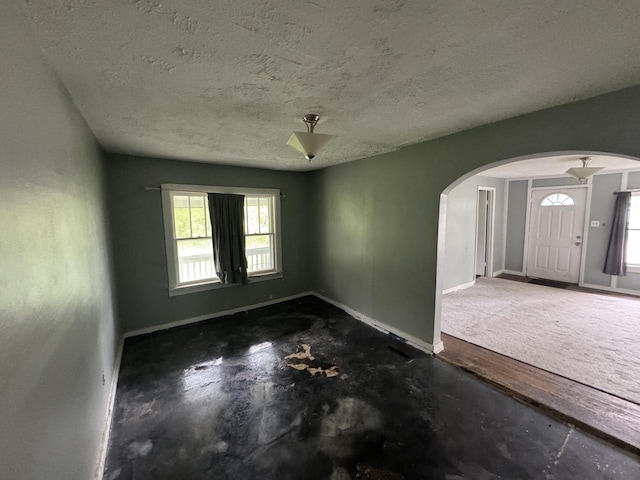 30728 113th St, Wilmot, WI 53181 - empty room featuring arched walkways, healthy amount of natural light, baseboards, and a textured ceiling