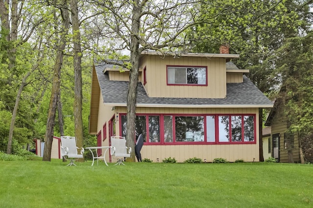 N7428 County Road J, Plymouth, WI 53073 - view of front of property featuring a shingled roof, a chimney, and a front lawn