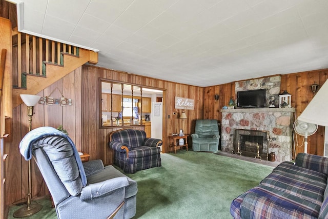 N7428 County Road J, Plymouth, WI 53073 - carpeted living room featuring wood walls, stairway, and a fireplace