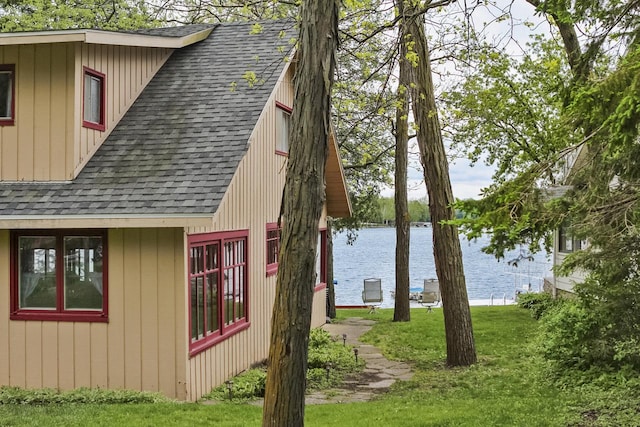 N7428 County Road J, Plymouth, WI 53073 - view of side of property featuring a shingled roof, a water view, and a lawn
