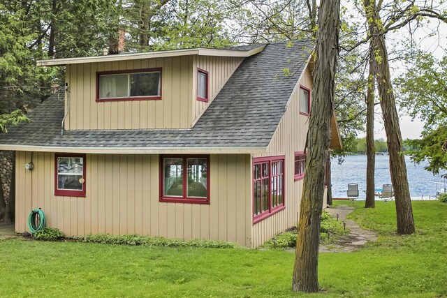 N7428 County Road J, Plymouth, WI 53073 - view of home's exterior featuring a shingled roof, a water view, and a lawn
