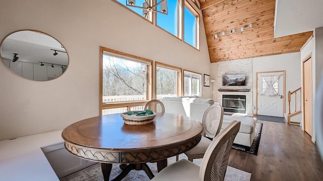 W11202 Apache Rd, Plainfield, WI 54966 - dining space featuring high vaulted ceiling, healthy amount of natural light, wood finished floors, a stone fireplace, and wooden ceiling