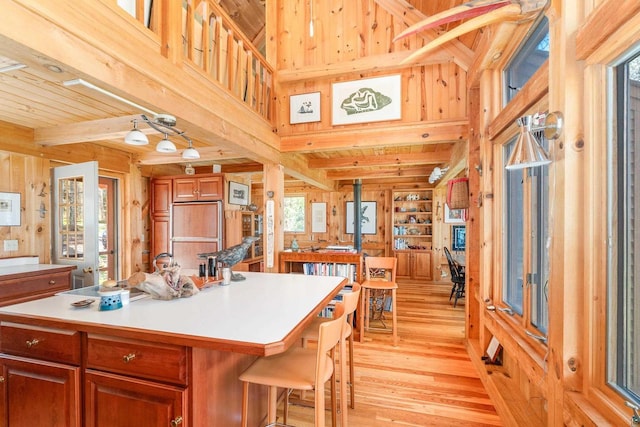 3610 N Shore Rd, La Pointe, WI 54850 - kitchen with wood walls, light wood-type flooring, paneled fridge, light countertops, and a center island
