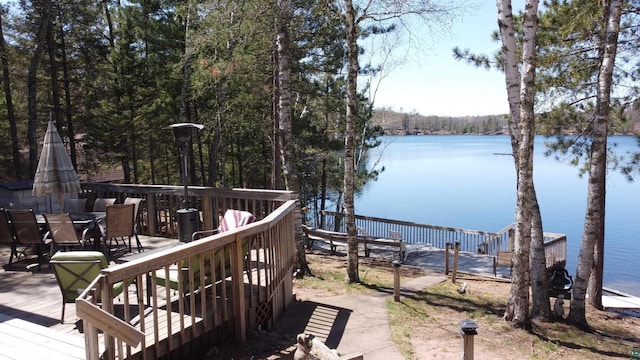 65485 Millicent Point Dr, Iron River, WI 54847 - wooden terrace featuring a water view, outdoor dining area, and a view of trees