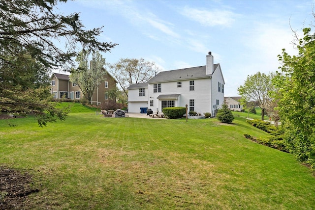 1755 Laura Ln, Port Washington, WI 53074 - rear view of house featuring a patio area, a chimney, a lawn, and a garage