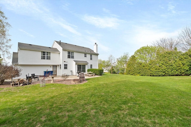 1755 Laura Ln, Port Washington, WI 53074 - back of property with a patio area, an outdoor fire pit, a lawn, and a chimney