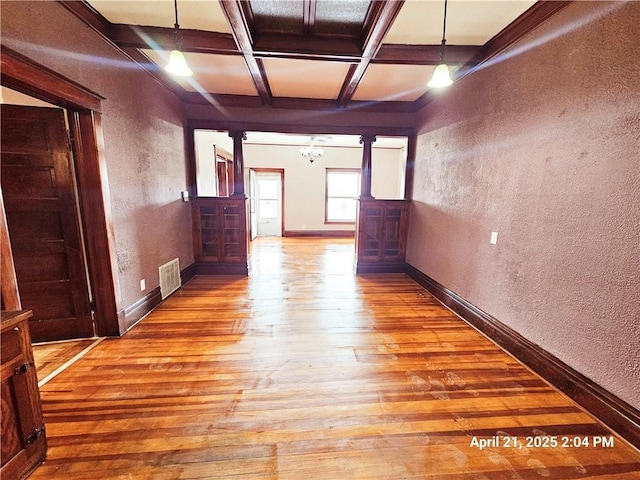 23716 Washington St # 1/ # 2, Independence, WI 54747 - unfurnished room with wood-type flooring, a textured wall, coffered ceiling, beam ceiling, and a chandelier