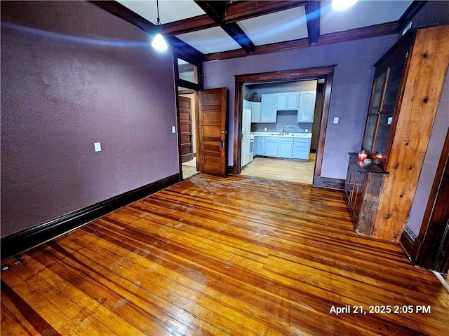 23716 Washington St # 1/ # 2, Independence, WI 54747 - unfurnished room featuring light wood-type flooring, coffered ceiling, baseboards, beam ceiling, and a textured wall
