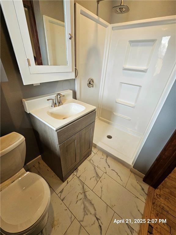 23716 Washington St # 1/ # 2, Independence, WI 54747 - bathroom featuring marble look tile flooring, a shower stall, toilet, and vanity