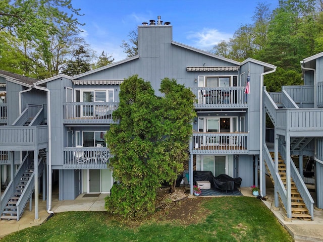 131 Lance Dr Unit 14, Twin Lakes, WI 53181 - rear view of house with stairway and a chimney