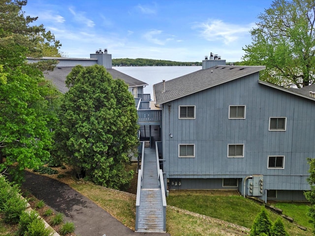 131 Lance Dr Unit 14, Twin Lakes, WI 53181 - rear view of house featuring a shingled roof, stairs, a chimney, and a balcony