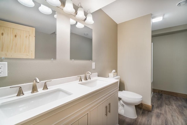 1996 Tucker Trl, Eau Claire, WI 54703 - bathroom featuring toilet, wood finished floors, double vanity, and baseboards