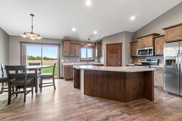 1996 Tucker Trl, Eau Claire, WI 54703 - kitchen featuring appliances with stainless steel finishes, lofted ceiling, a center island, wood finished floors, and a chandelier