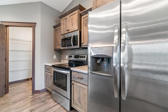 1996 Tucker Trl, Eau Claire, WI 54703 - kitchen with appliances with stainless steel finishes, light wood finished floors, light countertops, vaulted ceiling, and baseboards