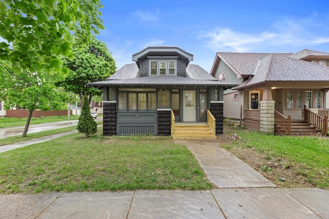 2976 N 40th St, Milwaukee, WI 53210 - bungalow-style home with a porch, a shingled roof, and a front lawn