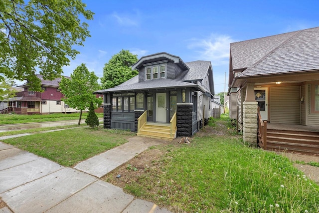 2976 N 40th St, Milwaukee, WI 53210 - bungalow featuring covered porch, a shingled roof, and a front lawn