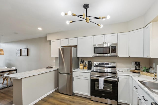 874 Xanadu Rd, Wisconsin Dells, WI 53965 - kitchen with stainless steel appliances, a chandelier, a peninsula, white cabinetry, and recessed lighting