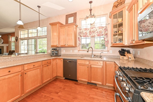 8940 Marie Ct, Mount Pleasant, WI 53406 - kitchen featuring appliances with stainless steel finishes, a sink, light wood-style flooring, light brown cabinets, and glass insert cabinets