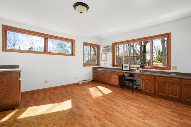 6208 Indian Mound Dr, Mcfarland, WI 53558 - unfurnished office featuring baseboard heating, light wood-style flooring, built in desk, a wall unit AC, and a baseboard heating unit