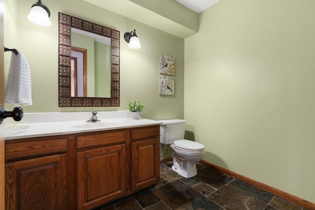 6208 Indian Mound Dr, Mcfarland, WI 53558 - bathroom with toilet, baseboards, stone tile floors, and vanity