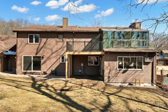 6208 Indian Mound Dr, Mcfarland, WI 53558 - rear view of house with a chimney, a balcony, a lawn, and cooling unit