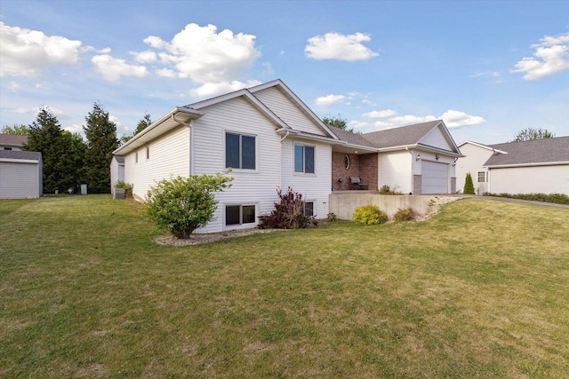 605 E Rime St, Orfordville, WI 53576 - back of house with an attached garage, a yard, and driveway
