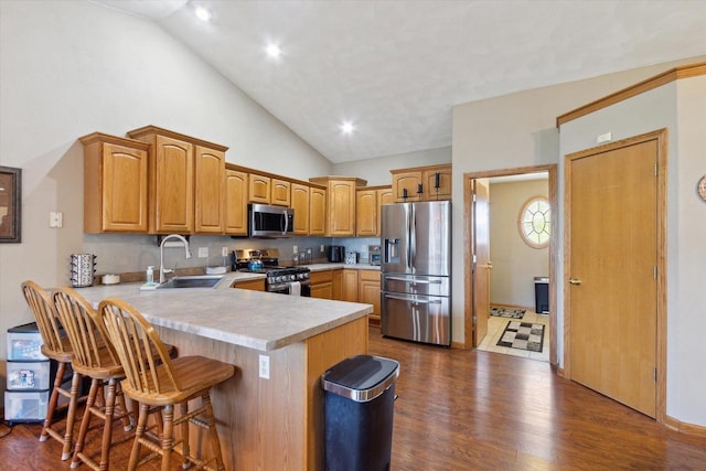 605 E Rime St, Orfordville, WI 53576 - kitchen with appliances with stainless steel finishes, a sink, a peninsula, light countertops, and a breakfast bar