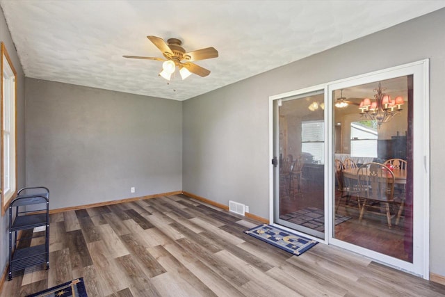 605 E Rime St, Orfordville, WI 53576 - empty room with wood finished floors, a chandelier, baseboards, and ceiling fan