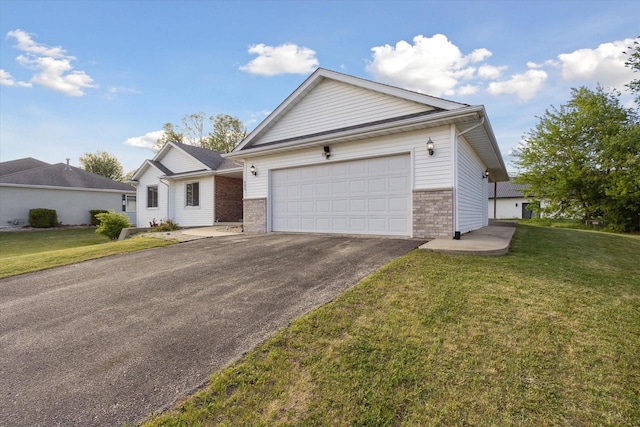 605 E Rime St, Orfordville, WI 53576 - view of front of home featuring driveway, brick siding, a front lawn, and a garage