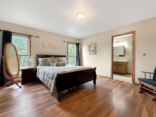 N2242 Keller Rd, Marinette, WI 54143 - bedroom featuring multiple windows, light wood finished floors, connected bathroom, and baseboards
