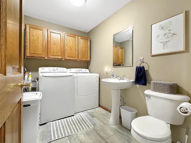 N2242 Keller Rd, Marinette, WI 54143 - laundry area featuring washer and clothes dryer, light wood finished floors, and baseboards