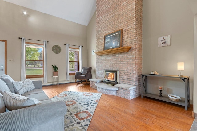 N3270 State Rd 76, Hortonville, WI 54944 - living area featuring high vaulted ceiling, a fireplace, wood finished floors, and a baseboard heating unit