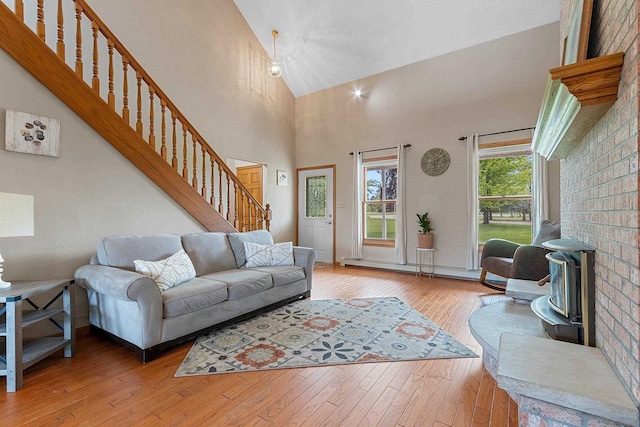 N3270 State Rd 76, Hortonville, WI 54944 - living area featuring stairway, light wood-type flooring, high vaulted ceiling, and a baseboard heating unit