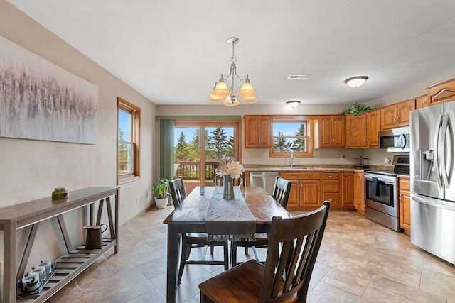N3270 State Rd 76, Hortonville, WI 54944 - kitchen with appliances with stainless steel finishes, a chandelier, a sink, brown cabinets, and pendant lighting