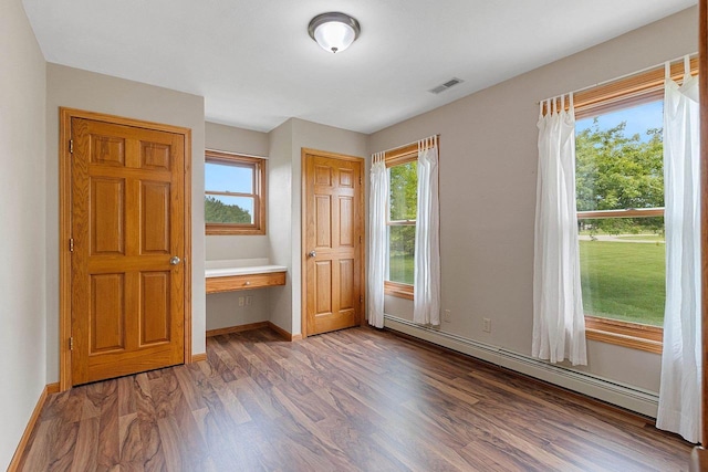 N3270 State Rd 76, Hortonville, WI 54944 - unfurnished bedroom featuring a baseboard heating unit, wood finished floors, and baseboards