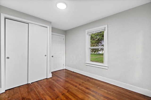 5015 N 25th St, Milwaukee, WI 53209 - unfurnished bedroom with baseboards, dark wood-style flooring, and a closet