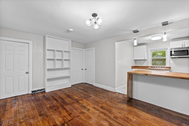 5015 N 25th St, Milwaukee, WI 53209 - kitchen with butcher block counters, stainless steel microwave, white cabinets, dark wood finished floors, and a sink