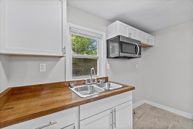 5015 N 25th St, Milwaukee, WI 53209 - kitchen featuring stainless steel microwave, a sink, wood counters, and white cabinets
