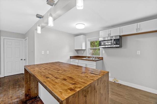 5015 N 25th St, Milwaukee, WI 53209 - kitchen featuring stainless steel microwave, butcher block counters, dark wood finished floors, and a sink