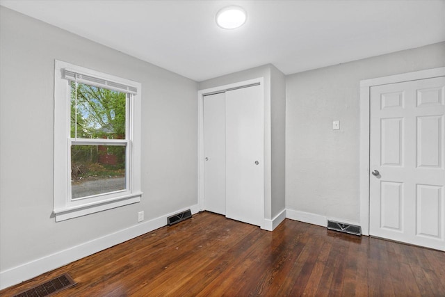 5015 N 25th St, Milwaukee, WI 53209 - unfurnished bedroom featuring dark wood-type flooring, baseboards, and a closet