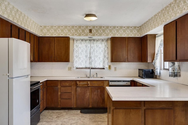 2530 Onalaska Ave, La Crosse, WI 54603 - kitchen featuring freestanding refrigerator, stainless steel electric range, light countertops, a sink, and a peninsula