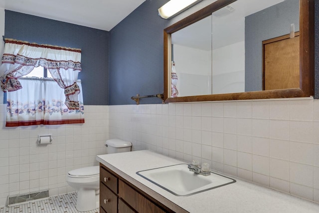 2530 Onalaska Ave, La Crosse, WI 54603 - bathroom with tile walls, toilet, vanity, and tile patterned floors