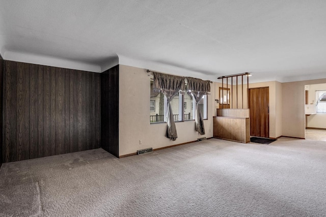 2530 Onalaska Ave, La Crosse, WI 54603 - unfurnished living room featuring carpet flooring, wooden walls, and baseboards