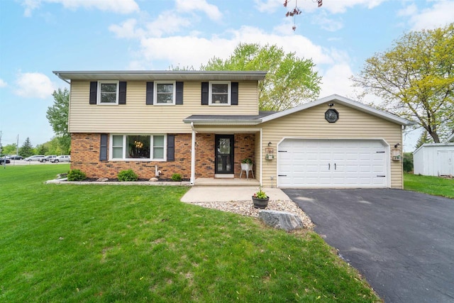 1089 Audrey Ct, North Fond Du Lac, WI 54937 - view of front of house with asphalt driveway, an attached garage, brick siding, and a front lawn