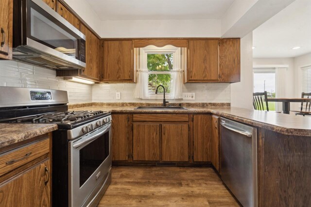 1089 Audrey Ct, North Fond Du Lac, WI 54937 - kitchen featuring stainless steel appliances, a sink, dark wood finished floors, backsplash, and dark countertops